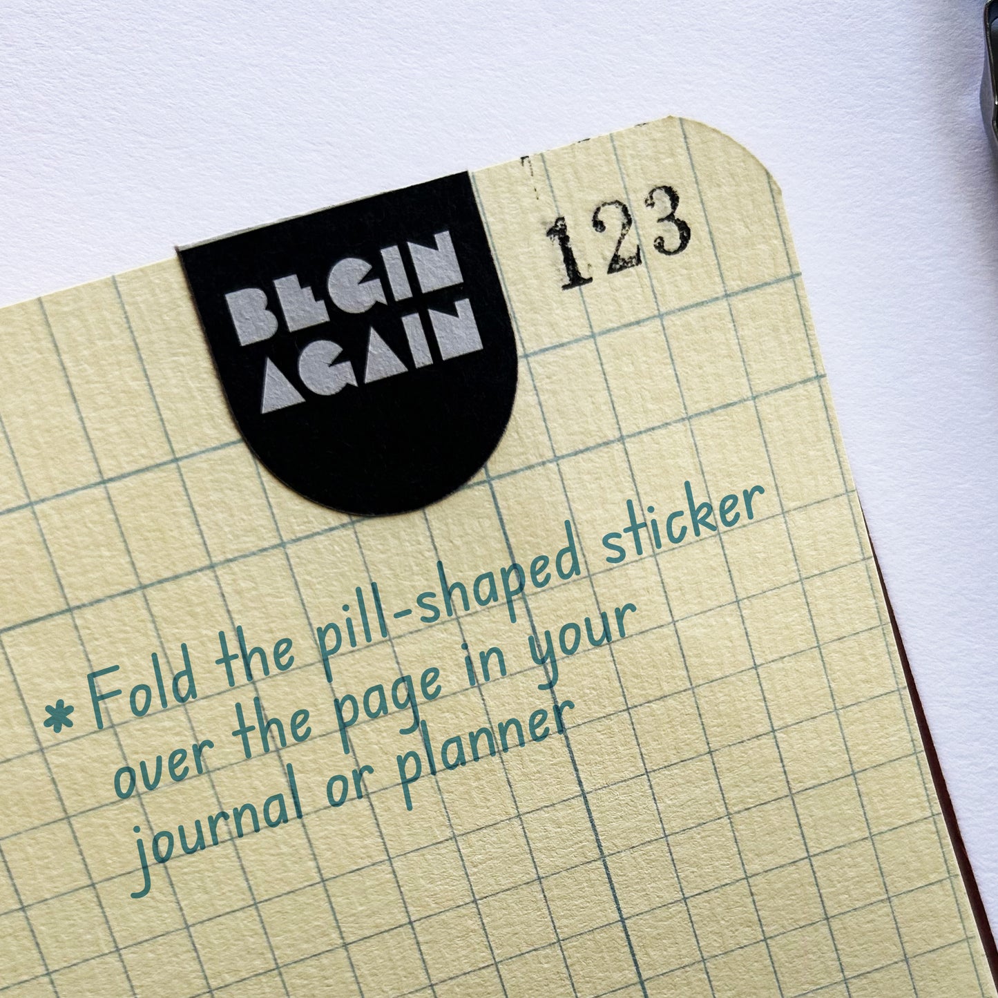 Close-up of Pills for Life sticker folded over notebook page